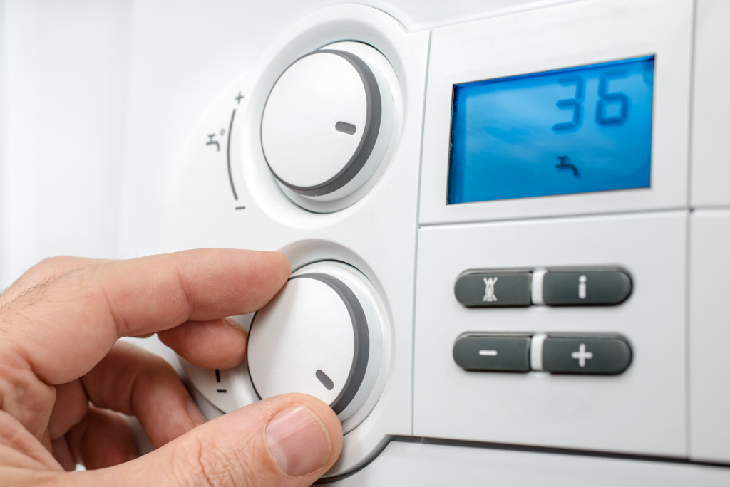 a man controlling thermostat at home